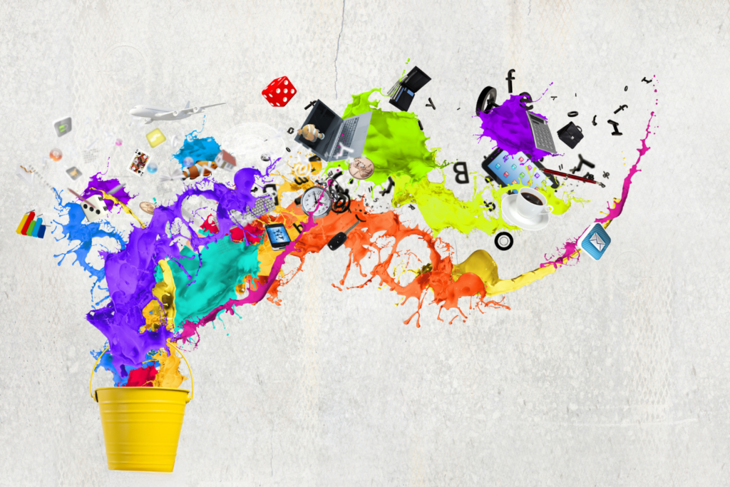 An abstract photograph of a bucket with a myriad colors of paint splashing out and above it.
